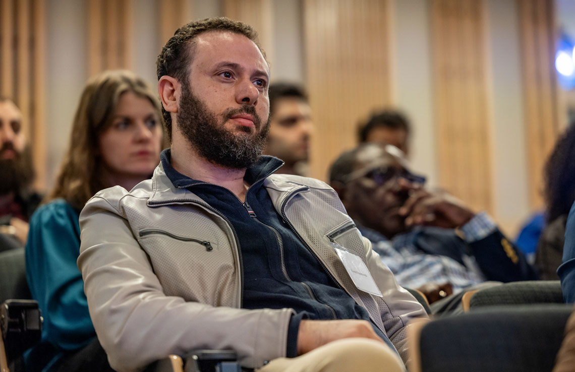 an attendee sitting while listening intently to a presentation