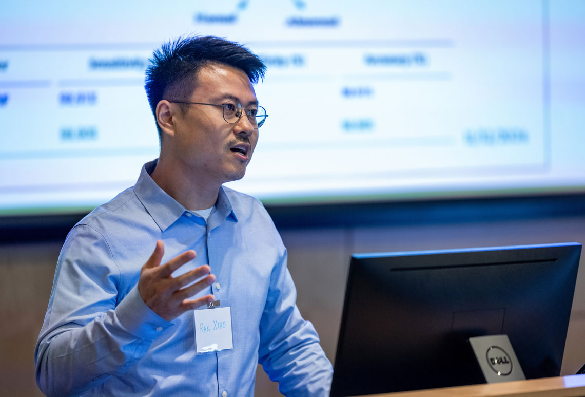 Ran Xiao speaking at a podium